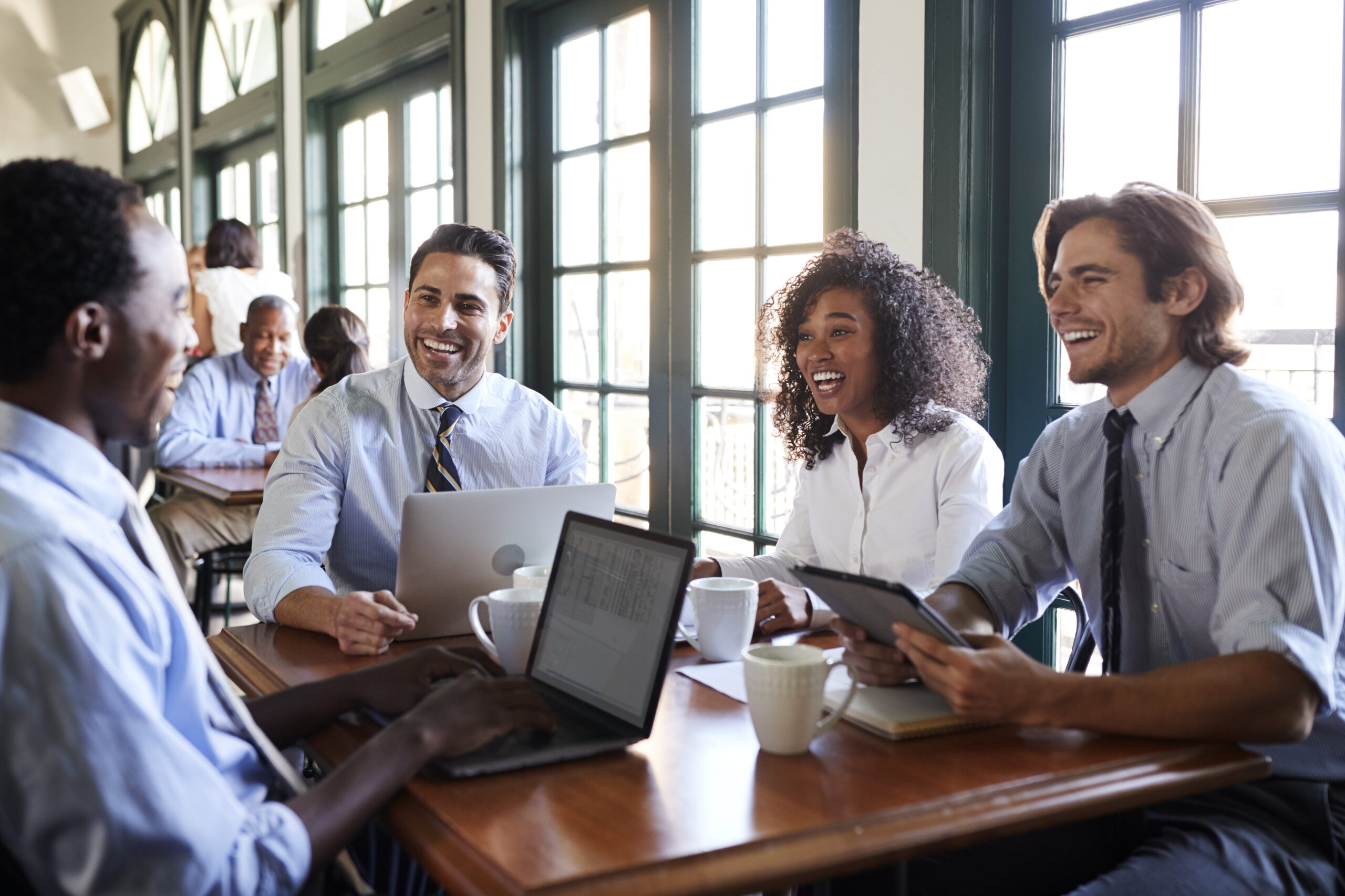 Business Team Having Informal Meeting Around Table In Coffee Shop